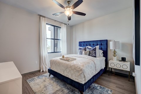 a bedroom with a large bed and a ceiling fan